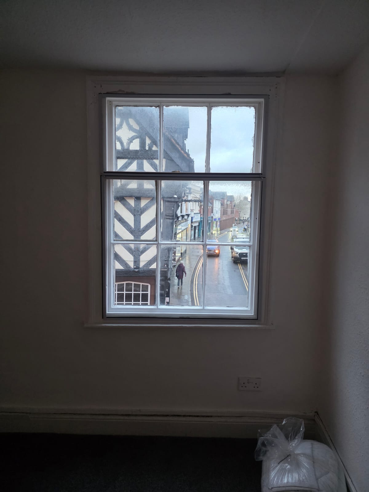 Secondary glazing on sash window in period property above a traditional town high street