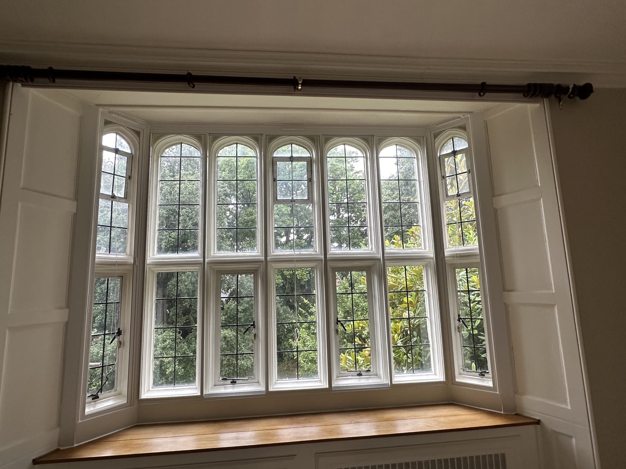 Grand bay window secondary glazing on large heritage property with six arched panels and garden views