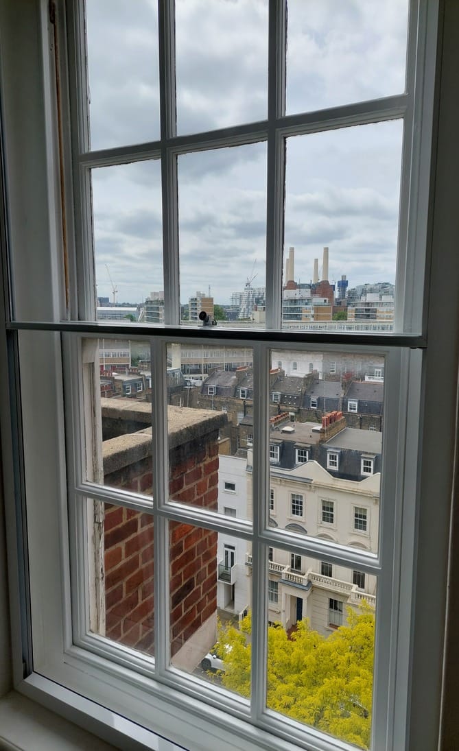 Vertical sliding secondary glazing on tall sash window with London cityscape view including Battersea Power Station