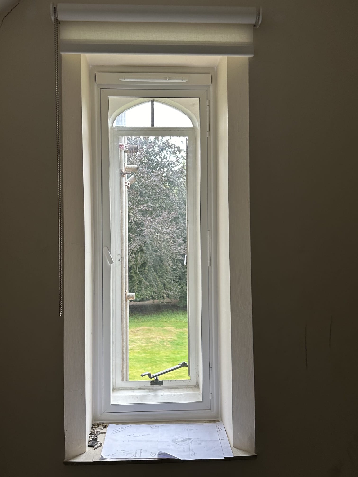Three-panel arched secondary glazing with vertical sliders on large heritage property window — freshly installed