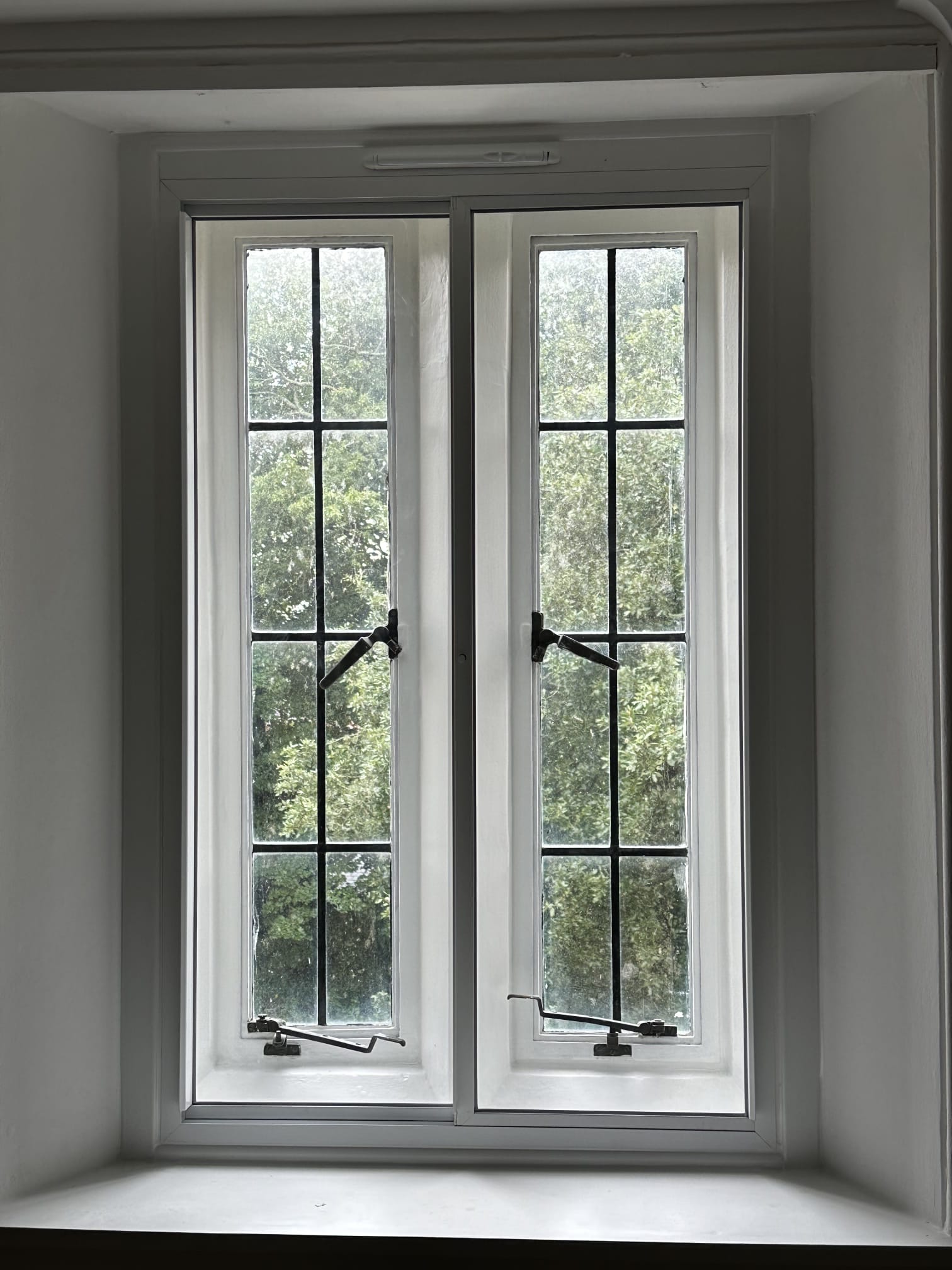 Three arched heritage windows with secondary glazing installed — vertical sliders matching original frame profile